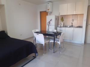 波薩達斯的住宿－Rincón Ejecutivo，餐桌、白色椅子和厨房