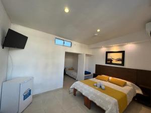 a bedroom with a bed and a television in it at Gran Colonial Riviera in Piriápolis