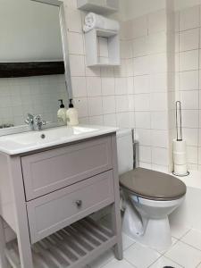 a white bathroom with a toilet and a sink at Studio Place d’Italie/Denfert-Rochereau in Paris