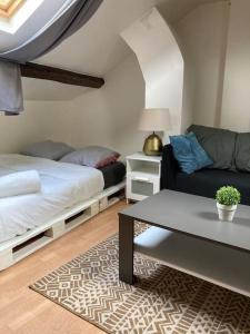 a bedroom with a bed and a couch and a table at Studio Place d’Italie/Denfert-Rochereau in Paris