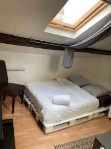 una camera con due letti in una stanza con finestra di Studio Place d’Italie/Denfert-Rochereau a Parigi
