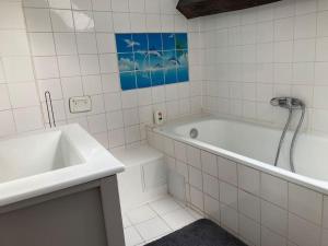 un bagno bianco con vasca e lavandino di Studio Place d’Italie/Denfert-Rochereau a Parigi