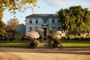 Prospect Country House & Restaurant في ريتشموند: أمامه بيت أبيض كبير وبه زهور