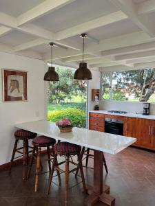 a kitchen with a large white table and stools at Chalet Andino Sesquile in Suesca