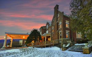 a large brick building with snow in front of it at Wilburton Inn in Manchester