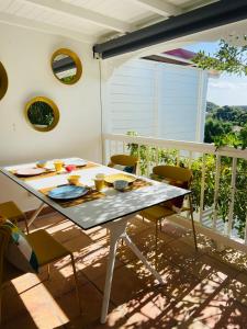 une table et des chaises sur le balcon d'une maison dans l'établissement Le Rocher, à Gustavia