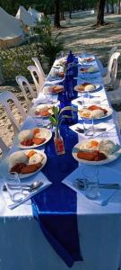 a long blue table with plates of food on it at Puerto Silanguin Beach Camping Resort in Zambales