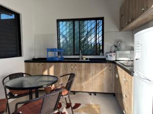 eine Küche mit einem Tisch, Stühlen und einem Waschbecken in der Unterkunft Pasifika Guesthouse in Nadi