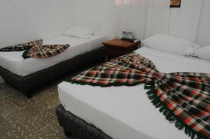 Dos camas con pañuelos en una habitación en Hotel Montecarlo Beach, en Tolú