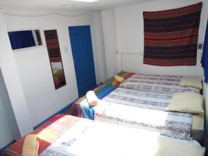 1 dormitorio con 2 camas individuales y ventana en Posada Azul Cusco, en Cusco