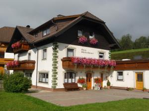 a large white building with flowers on it at Sonnenchalet Bäckenbauer in Sankt Michael im Lungau