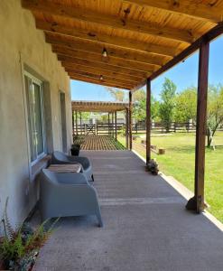 a patio with chairs and a wooden pergola at Aluminé in Colón
