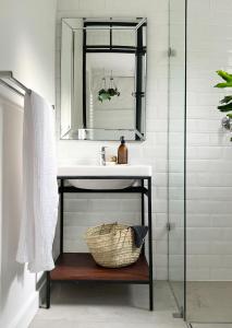 a bathroom with a sink and a basket under a mirror at Waterkant House - 151 in Cape Town +18 photos