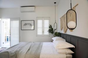 a bedroom with a bed with white sheets and pillows at Waterkant House - 151 in Cape Town