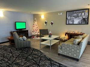 a living room with a christmas tree and a television at Super 8 by Wyndham Escanaba in Escanaba