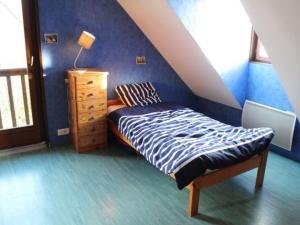 a bedroom with a bed and a dresser in a attic at Gîte Bénaménil, 5 pièces, 6 personnes - FR-1-584-4 