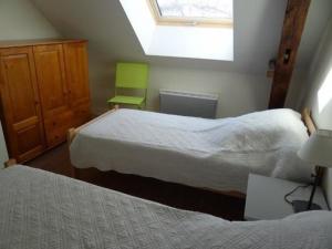 1 dormitorio con 2 camas y silla verde en Gîte La Bazoge, 6 pièces, 10 personnes - FR-1-410-213, en La Bazoge