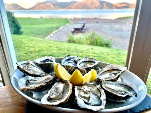 a plate of oysters on a plate with lemon slices at Holly Tree Hotel, Swimming Pool & Hot Tub in Glencoe