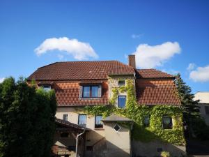 a house with ivy on the side of it at Pension Kirschgarten in Nebra