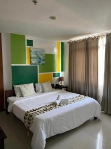 2 Betten in einem Zimmer mit Grün und Gelb in der Unterkunft BOPEMPC Safari Hostel in Tagbilaran
