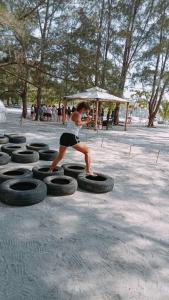 a man standing on a bunch of tires at Puerto Silanguin Beach Camping Resort in Zambales