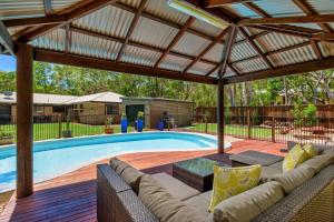 a swimming pool with a pergola next to a swimming pool at 13 Orania Court in Rainbow Beach