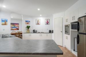 a kitchen with white cabinets and a counter top at 13 Orania Court in Rainbow Beach