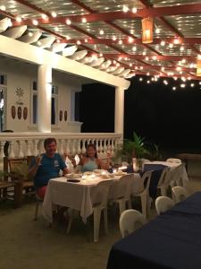 two people sitting at a table in a restaurant at Puerto Silanguin Beach Camping Resort in Zambales