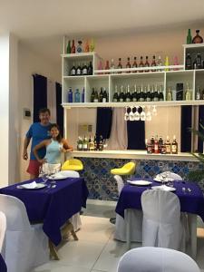 a man and a woman standing in a restaurant with tables at Puerto Silanguin Beach Camping Resort in Zambales