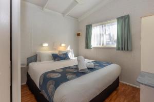 a hotel room with a large bed and a window at BIG4 Breeze Holiday Parks - Port Hughes in Port Hughes