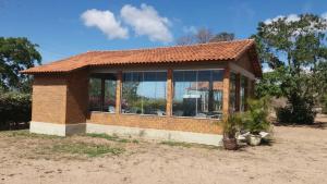 a small brick house with a large group of windows at Casa com piscina em Gravatá PE in Gravatá