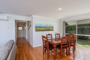 a dining room with a table and chairs and a couch at Rainbow Tides in Rainbow Beach