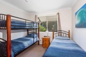 two bunk beds in a room with a window at Rainbow Tides in Rainbow Beach