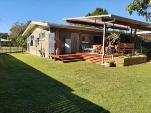 a small house with a porch and a yard at Surf N Earth in Rainbow Beach