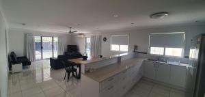 a kitchen with a counter and a table and chairs at 62 Tingira Close - Modern lowset home with swimming pool, outdoor area, ample parking. Pet friendly in Rainbow Beach