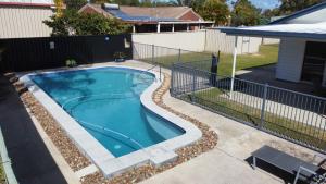 a swimming pool with a fence next to a house at 62 Tingira Close - Modern lowset home with swimming pool, outdoor area, ample parking. Pet friendly in Rainbow Beach