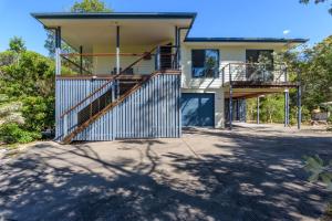 a house with two decks and a staircase at Mortimer in Rainbow Beach