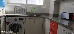a kitchen with a washing machine and a sink at La Serena vista al mar in La Serena