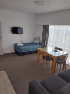 a living room with a table and a couch at Bayview Motel in Paihia