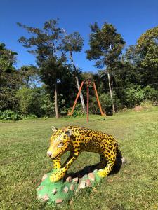 uma estátua de um jaguar em um campo com um playground em Canopy Wonders Vacation Home em Monteverde