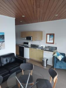 a living room with a couch and a table and chairs at Bayview Motel in Paihia