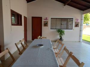 un comedor con una mesa larga y sillas en Casa Orquídea - Ingleses Norte - 2º andar, en Florianópolis