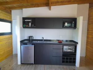 a kitchen with black cabinets and a sink at Muelle Delta Arias - EN TIGRE ISLA - in Tigre