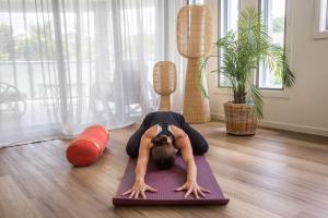 a woman doing a yoga pose on the floor at Currumbin Sanctuary Beach Abode in Gold Coast
