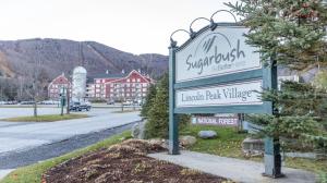 a sign for the entrance to an inn back village at Sugarbush Summit Condo in Warren