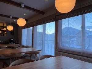 a restaurant with tables and chairs and a large window at SLOPE in Kutchan