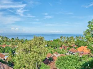 an aerial view of a village with the ocean in the background at Villa Mimpi Tamarind in Amed