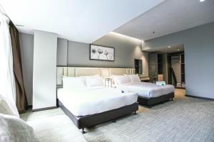 two beds in a hotel room with two beds at Fives Hotel DNP in Johor Bahru