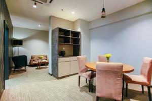 uma sala de jantar com uma mesa e cadeiras e um sofá em Fives Hotel DNP em Johor Bahru