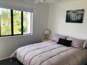 - une chambre avec un grand lit et une fenêtre dans l'établissement Rainbow Stairs, à Rainbow Beach